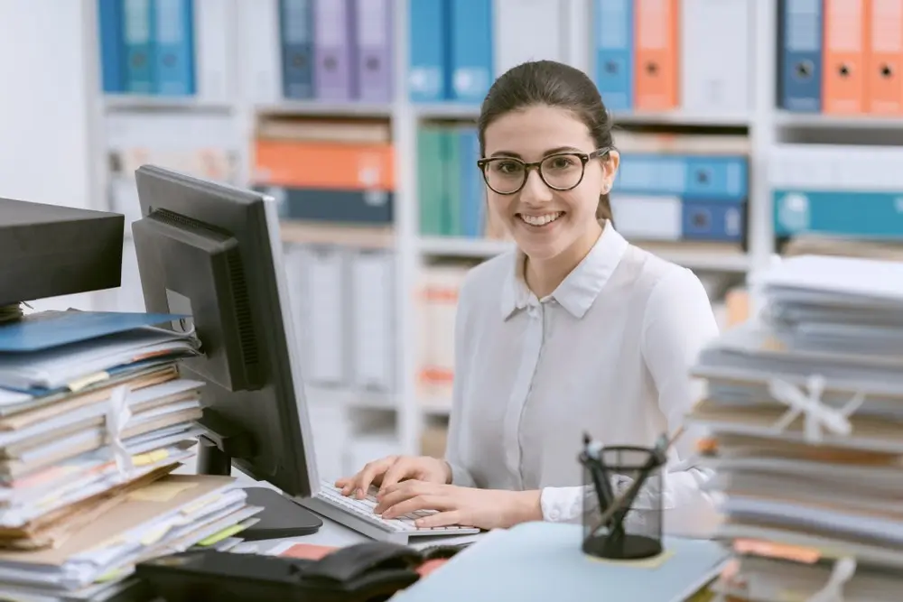 Female Accountant checking bookkeeping records Smiling female accountant checking bookkeeping records at work