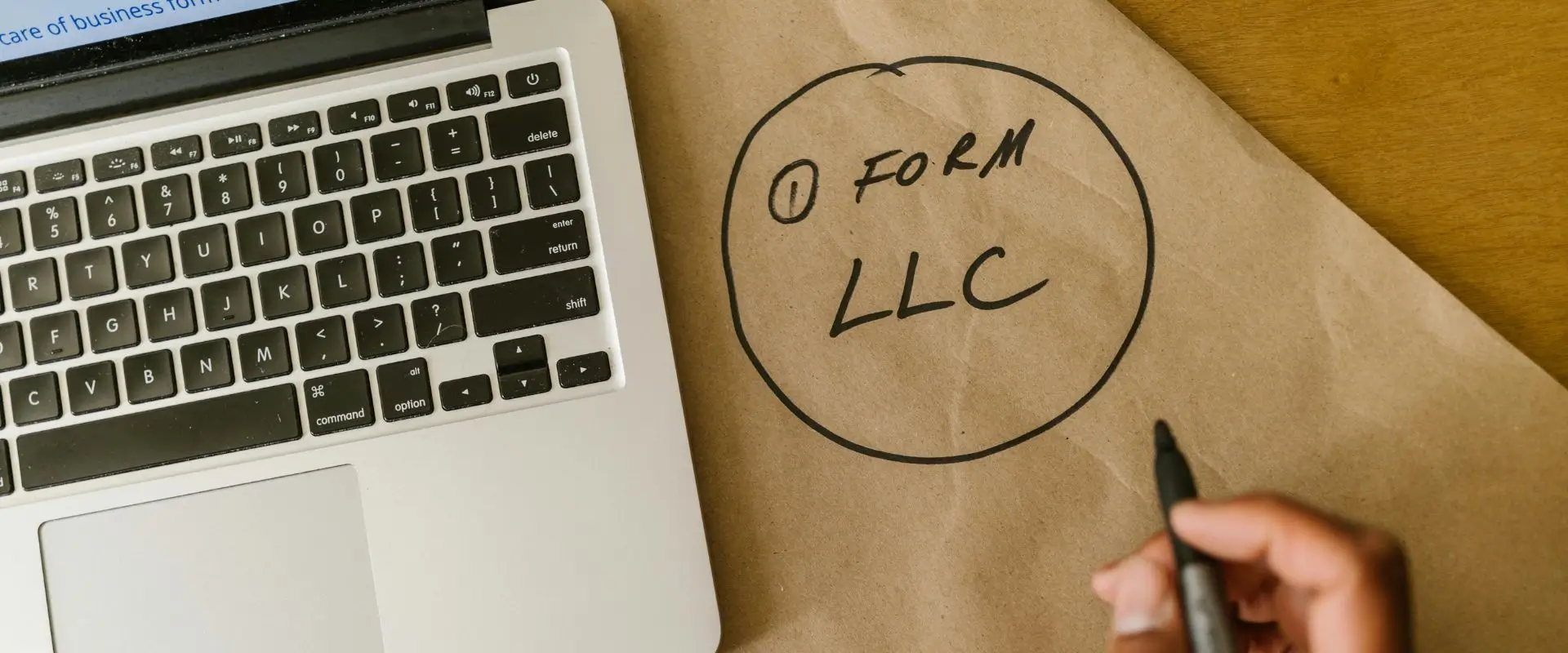 LLC Company Formation in Uk Working on a desk with a laptop while writing on a note Company Formation in Uk